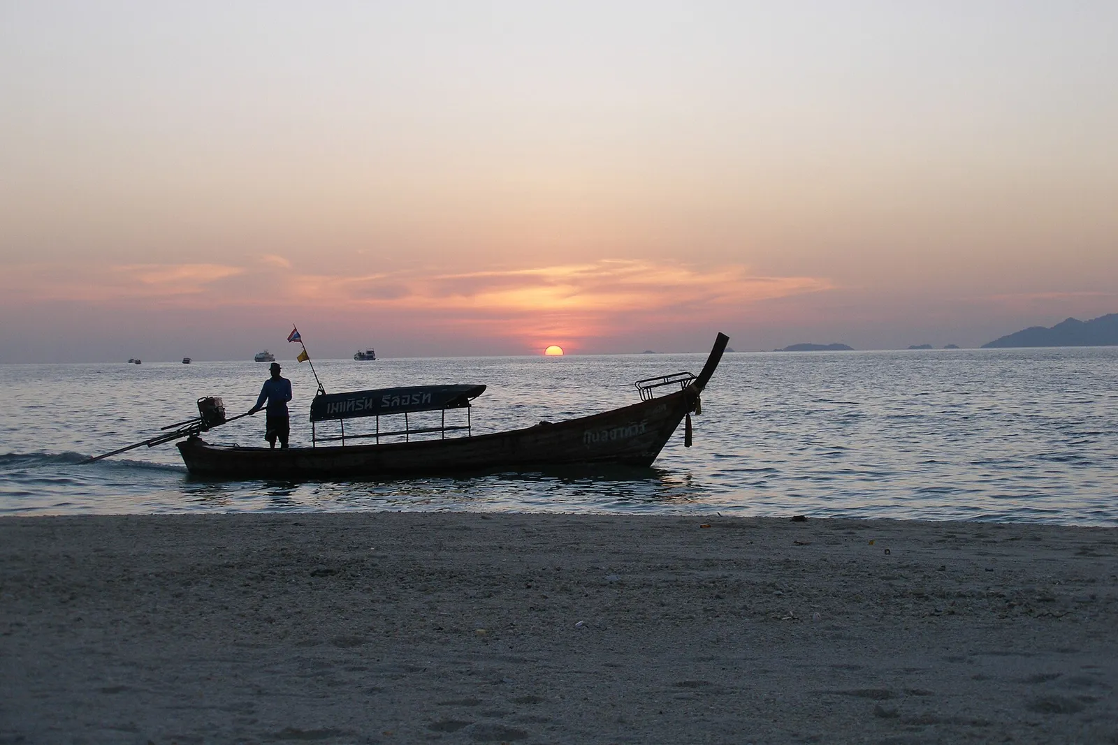 Longtail boat coming in to a Koh Lipe beach at sunset