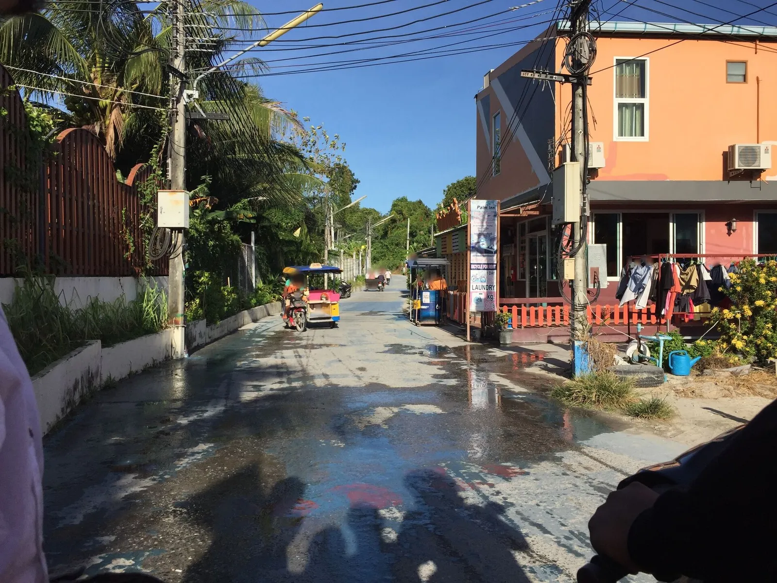 Paved street with shops and a tuk-tuk on Koh Lipe